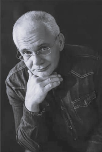 Mężczyzna podpiera ręką podbródek 