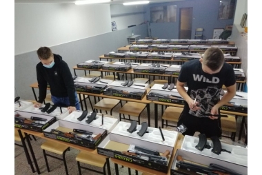 2 uczniów II LO w Chrzanowie  przed paczkami z karabinkami szturmowymi, wyciagają i oglądają broń