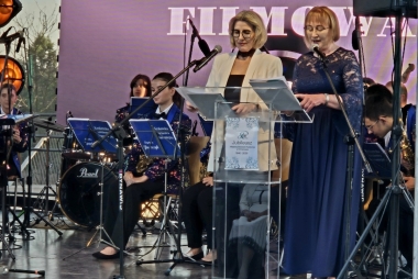 Dwie kobiety stoją na scenie i witają gości