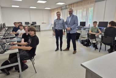 Dyrektor i nauczyciel wraz z uczniami w pracowni informatycznej