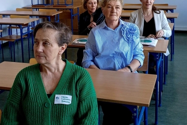 Kobiety siedzą w ławkach 