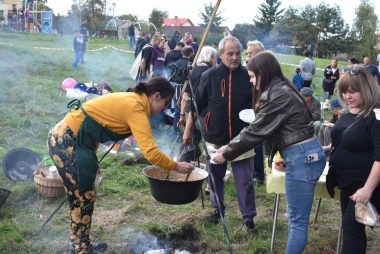 Garnek żeliwny. Obok miska z pieczonymi ziemniakami 