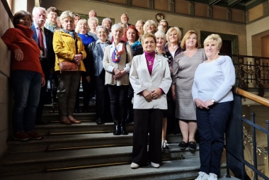 Na schodach pozują do zdjęcia kobiety i mężczyźni