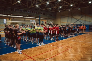 Zdjęcie zespołów złożonych z uczniów. Każda z ekip stoi w osobnym rzędzie na parkiecie w hali sportowej.