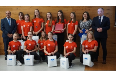 13 dziewczynek w czerwonych koszulkach i czarnych getrachw towarzystwie Starosty chrzanowksiego i Przewodniczącego Rady 