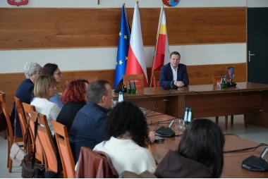 Zdjęcie kilkudziesięciu osób na sali narad siedzących przy stołach