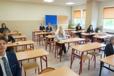 Uczniowie siedzą w ławkach 