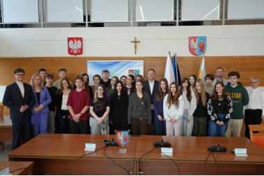 Zdjęcie kilkudziesięciu osób. Głównie uczniów, ale także kilku urzędników. W tle symbole państwowe i powiatu.