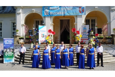 Zdjęcie kilkunastu osób, kobiet i mężczyzn w eleganckich strojach. 