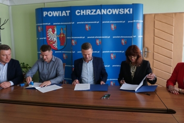 Trzech mężczyzn i dwie kobiety, przed nimi kartki - umowy 