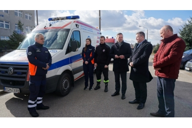 6 osób  stoi obok karetki 