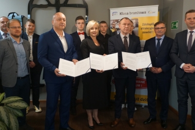 Grupa osób z rozłożonymi umowami 
