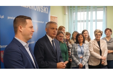 Zdjęcie Starosty Chrzanowskiego, Sekretarza Powiatu oraz pracowników starostwa. Sekretarza przemawia do zebranych osób. 