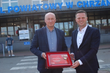 Dwóch mężćzyzn trzyma czerwoną paterę 
