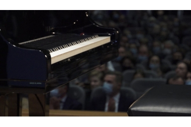 zdjecie pianina rzyt z lewej strony, w tle siedzi publicznosć 