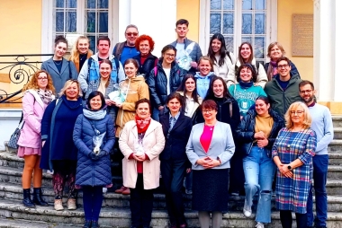 zdjęcie grupowe przedstawiciele pdps oraz studenci stoja na schodach przed budynkiem pałacu 