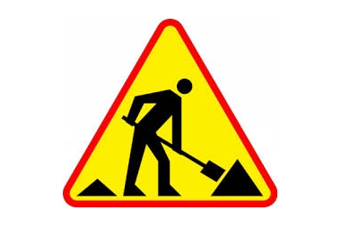 Znak drogowy. Żółty trójkąt z robotnikiem z łopatą